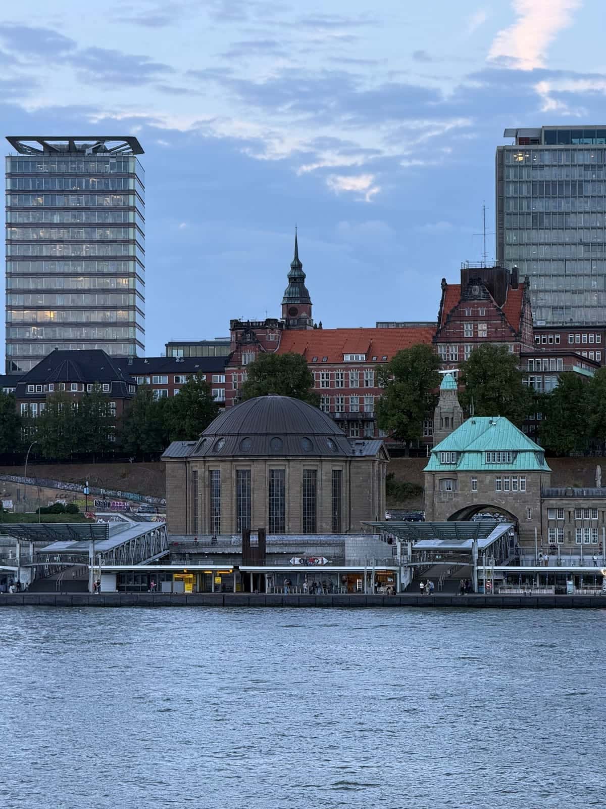 Vista sobre el Elba hacia el túnel de St. Pauli y el perfil urbano de Hamburgo al atardecer
